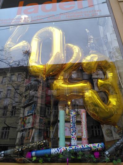 a shop window with golden baloons with 2023 dispalyed on them