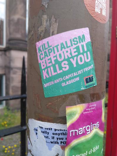 A sticker stuck to a lampost with kill capitalism before it kills you written on it. Sticker produced bt the green anti-capitalist front Glasgow