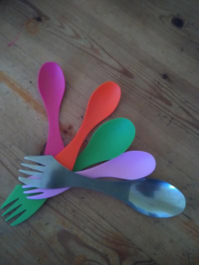 5 colourful sporks arranged on a wooden background