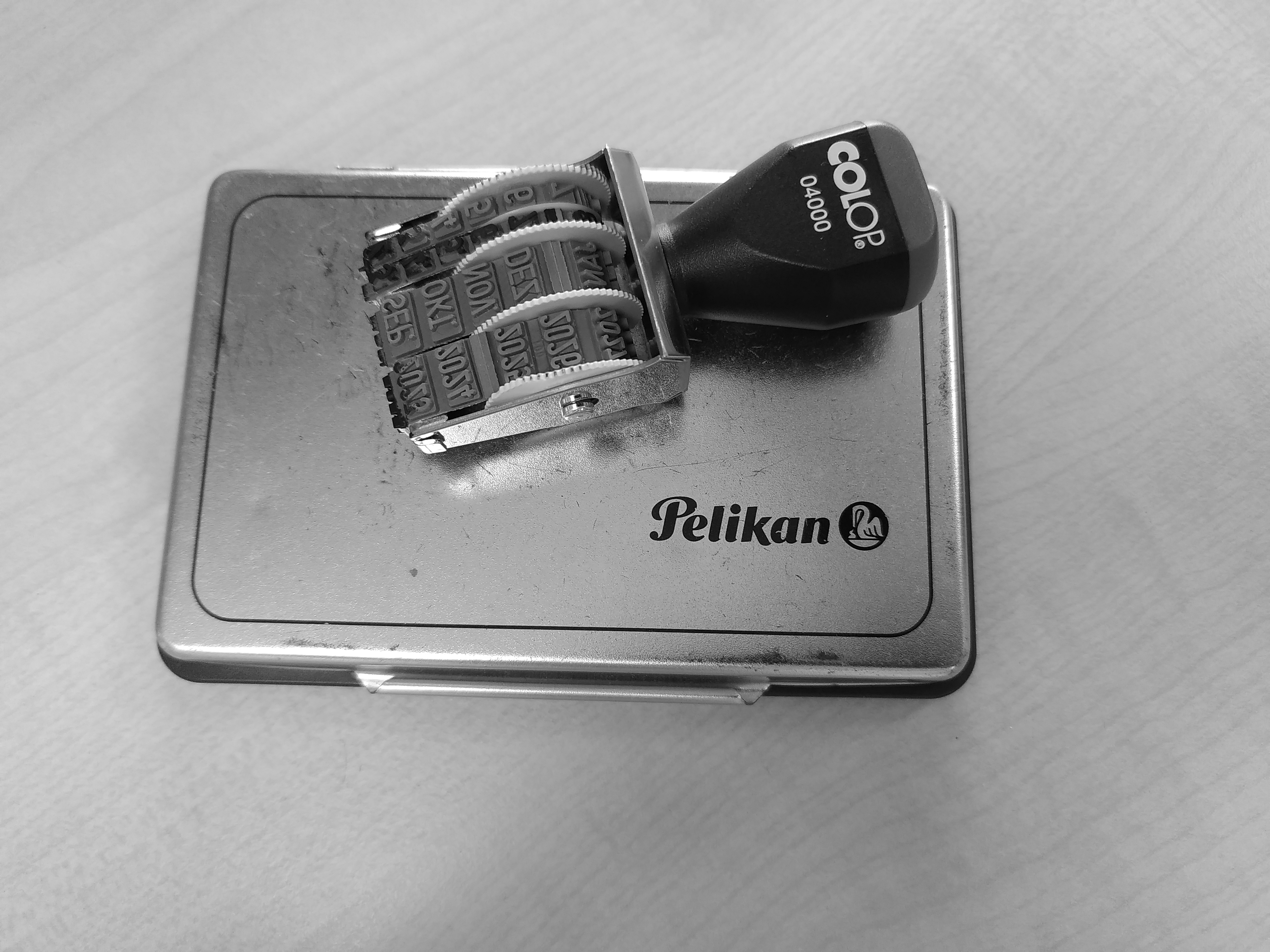 a black and white image of a date stamp placed on top of an ink pad